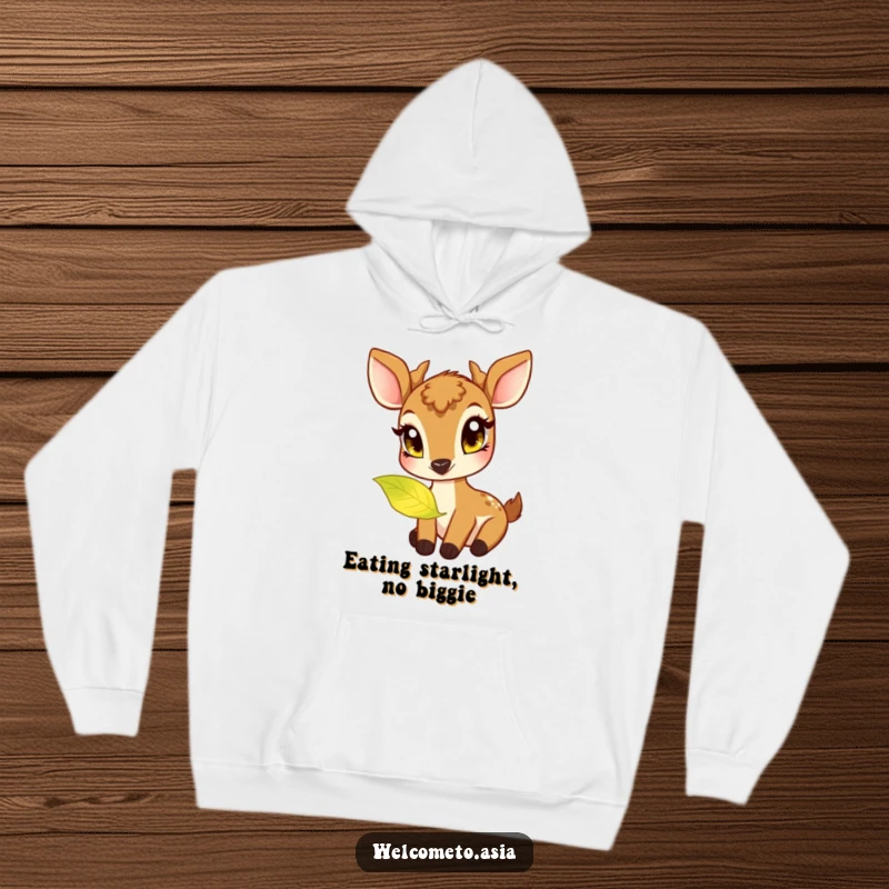 Funny hoodie featuring a friendly deer with big, curious eyes, nibbling a softly glowing magical leaf in a serene setting.