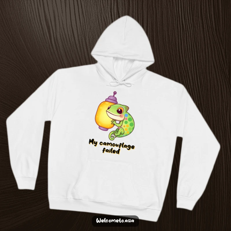 Funny hoodie with a giggling, colorful chameleon hilariously trying to camouflage itself against a glowing lantern, a whimsical and amusing scene.
